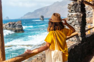 A tourist looking at the pools from the recreational area of La Maceta on the island of El Hierro