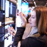 beautiful girl chooses perfume in a cosmetic store