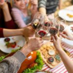 Happy family toasting with wine on Christmas eve. Multiracial family are celebrating holiday.