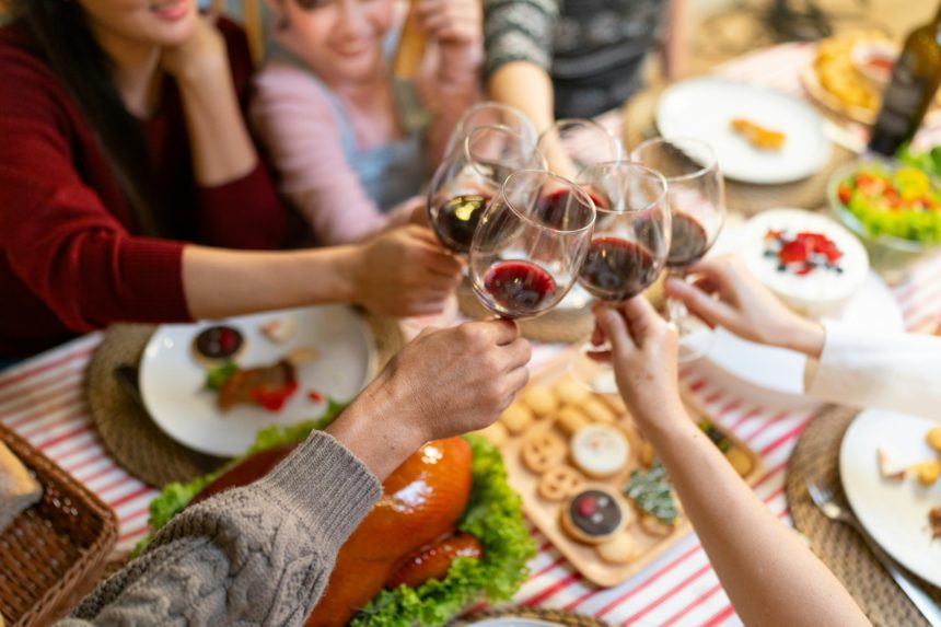 Happy family toasting with wine on Christmas eve. Multiracial family are celebrating holiday.