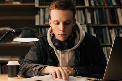 Male student reading from a book