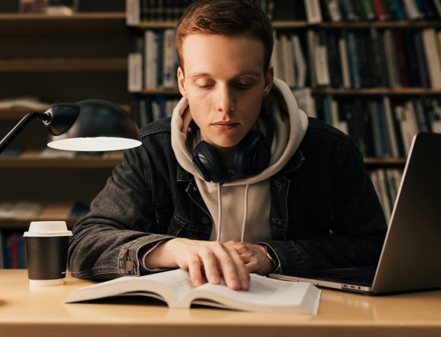 Male student reading from a book