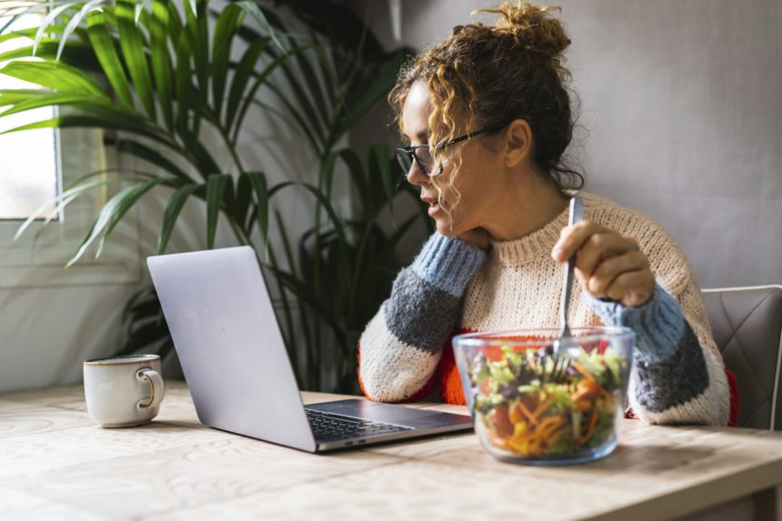 People eating fast and healthy in front of a computer during job lunch break. Modern business life