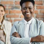 Portrait of happy black female leader and her business team at corporate office.