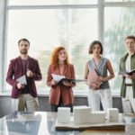 portrait of successful designers near innovative building model in office, project presentation