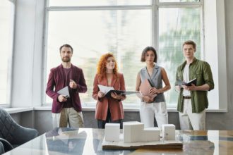 portrait of successful designers near innovative building model in office, project presentation