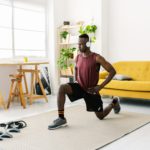 Young african man exercising doing fitness workout at home
