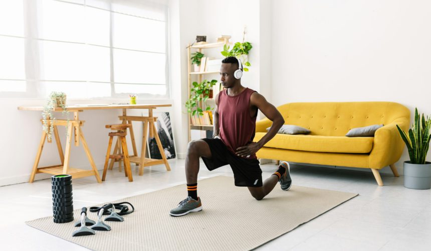 Young african man exercising doing fitness workout at home